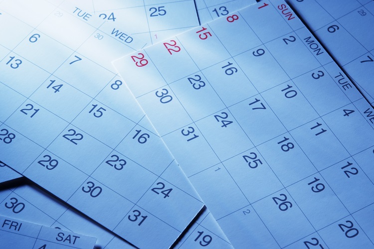 Blue tinted image of calendars with light rays