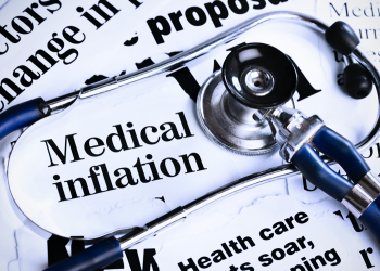 Stethoscope sits on newspaper headlines about medical inflation