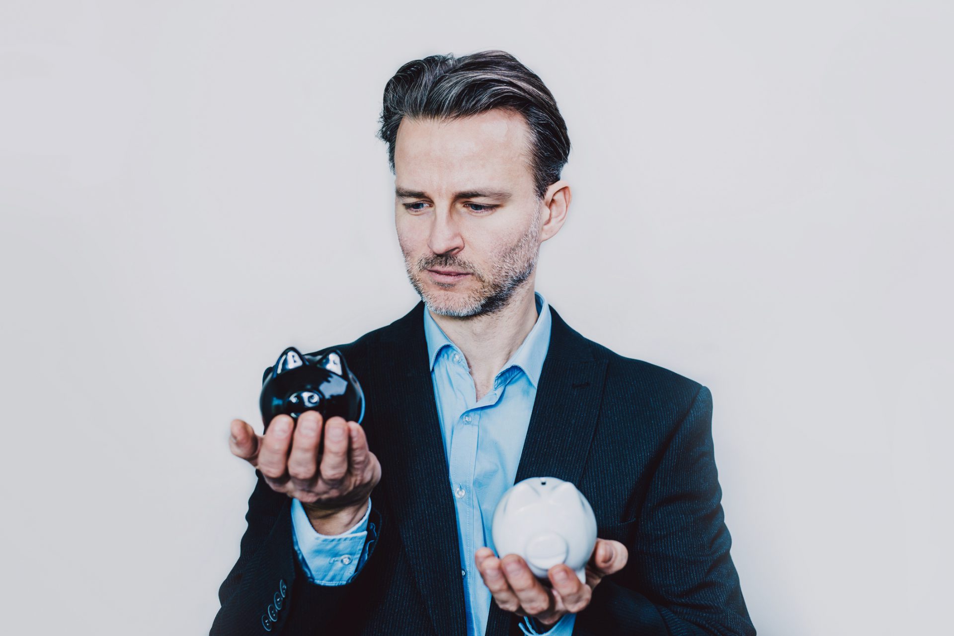 Businessman with black and white piggy bank.