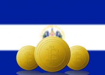 Three Bitcoins cryptocurrency with El Salvador flag on background.