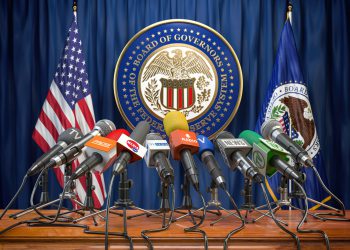 Federal Reserve System Fed of USA press conference concept. Microphones TV and radio channels with symbol and flag of US Federal Reserve. 3d illustration