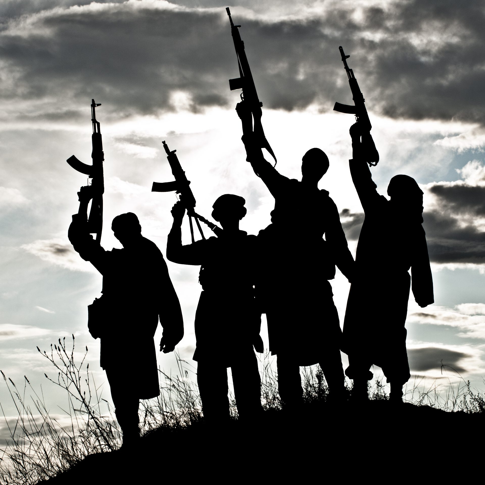 Silhouette of several militants with rifles