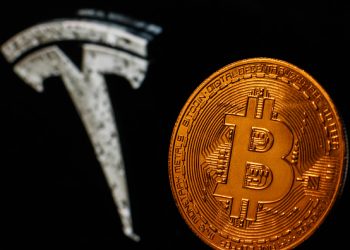 Representation of Bitcoin is seen with Tesla logo displayed in the background in this illustration photo taken in Krakow, Poland on July 9, 2021. (Photo by Jakub Porzycki/NurPhoto via Getty Images)