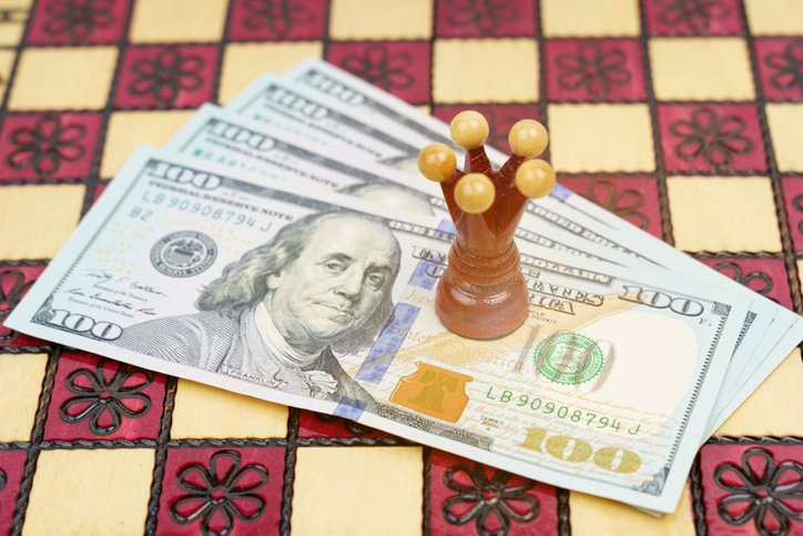 Business and success concept. On the chessboard there is money on which the red king stands.