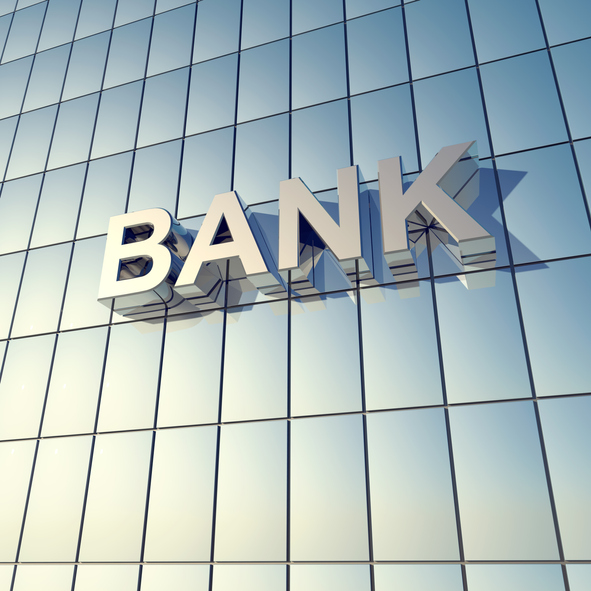 Glass front of a bank building with the word "BANK" on the Building