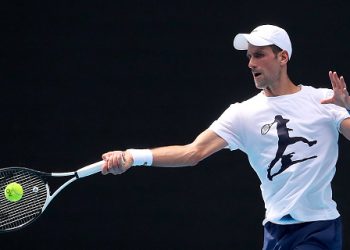 MELBOURNE, AUSTRALIA - JANUARY 11: Novak Djokovic of Serbia practices on Rod Laver Arena ahead of the 2022 Australian Open at Melbourne Park on January 11, 2022 in Melbourne, Australia. Djokovic arrived in Melbourne on Thursday night to play in the upcoming Australian Open and was denied entry to Australia due to his inability to meet Australian entry requirements. He was sent to an immigration detention hotel while the decision to cancel his visa was reviewed in the Australian Federal Circuit Court. Djokovic was granted permission to enter Australia on Monday night and resumed practising soon after with another session this afternoon, while the Federal Government decides if they should still cancel his visa. (Photo by Kelly Defina/Getty Images)