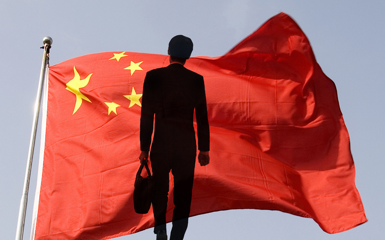 Businessman standing before Chinese flag.