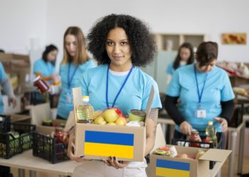 A female volunteer holding a donation box with food for people in need in Ukraine