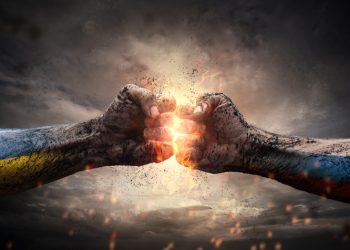 Close up of two fists hitting each other over dramatic sky