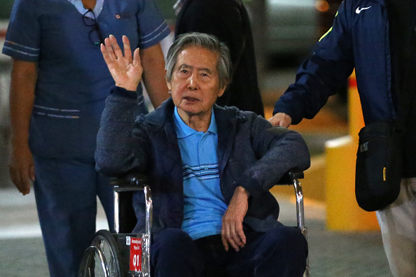 Peru's former President Alberto Fujimori waves to supporters as he is wheeled out of the Centenario Clinic in Lima on January 04, 2018, where he was hospitalised for the last twelve days and where he received a Christmas' eve pardon from President Kuczynski. - Fujimori was pardoned days after his son Kenji abstained from voting on Kuczynskis impeachment, drawing other lawmakers with him to deny the opposition the votes necessary to remove the president from office over corruption allegations. (Photo by LUKA GONZALES / AFP) (Photo by LUKA GONZALES/AFP via Getty Images)