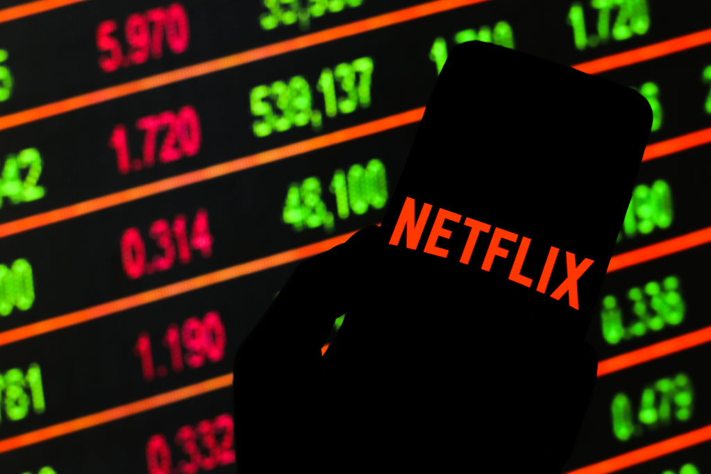 POLAND - 2020/03/13: In this photo illustration a Netflix logo seen displayed on a smartphone.Stock market prices in the background as stock markets tumble all over the world. (Photo by Filip Radwanski/SOPA Images/LightRocket via Getty Images)