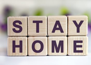 Text STAY HOME on wooden cubes with a floral background