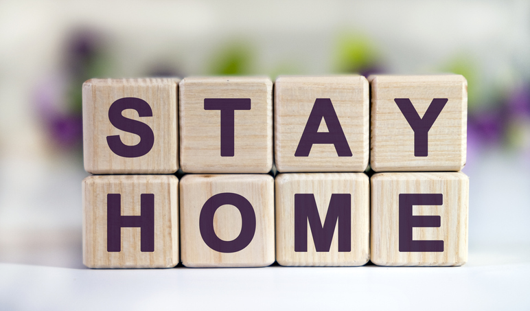 Text STAY HOME on wooden cubes with a floral background