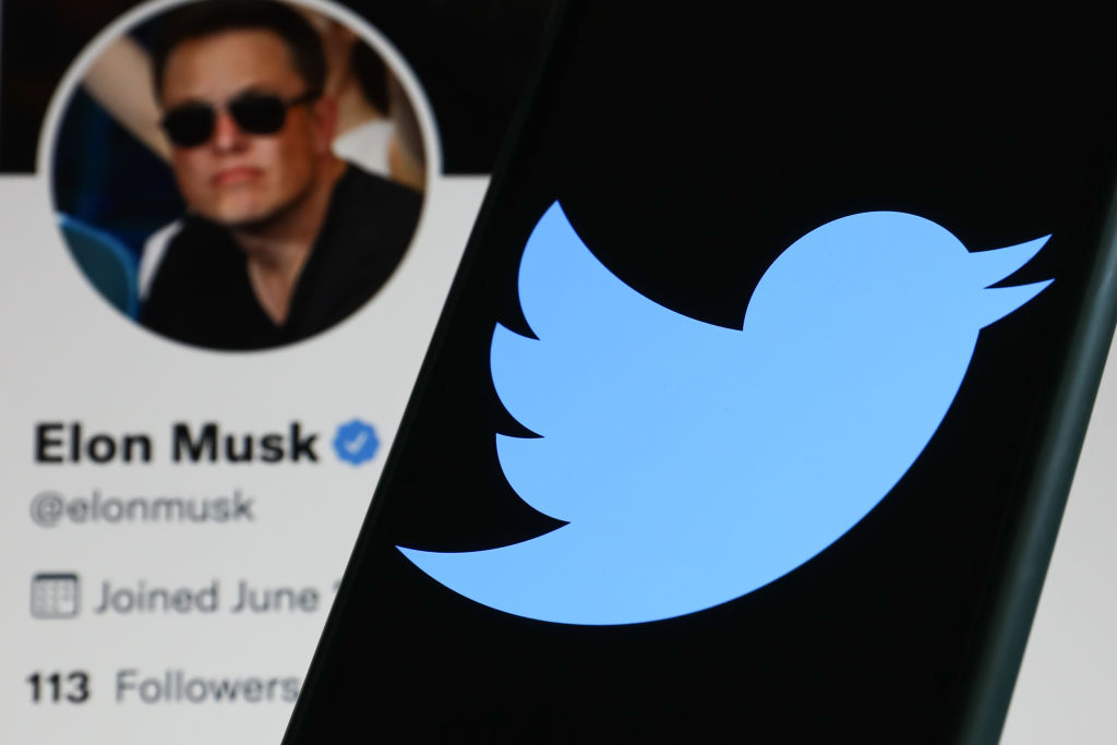 Twitter logo displayed on a phone screen and Elon Musk's Twitter profile displayed on a screen are seen in this illustration photo taken in Krakow, Poland on April 14, 2022. (Photo illustration by Jakub Porzycki/NurPhoto via Getty Images)
