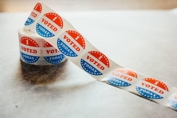 Roll of "I voted" circular stickers on a gray background for the November elections in the United States.