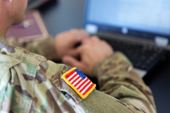 unrecognizable American soldier writing on a laptop