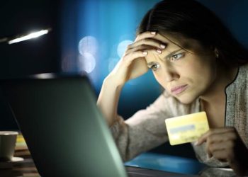 Worried woman in the night buying online at home