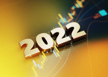 Gold colored 2022 sitting on yellow financial graph background. Horizontal composition with selective focus and copy space. Investment, stock market data and finance concept.