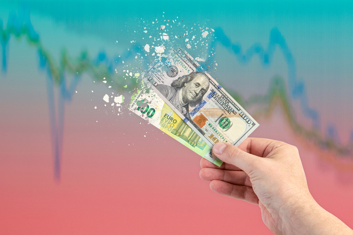 Inflation, hyperinflation, stagflation. One hundred dollar and one hundred euro banknotes splatter on the falling red graph. The concept of inflation and crisis in Europe and the United States