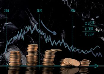 Coin stacks and receding economy graphs. Conceptual image of the economical situation and possible upcoming crisis in 2020.