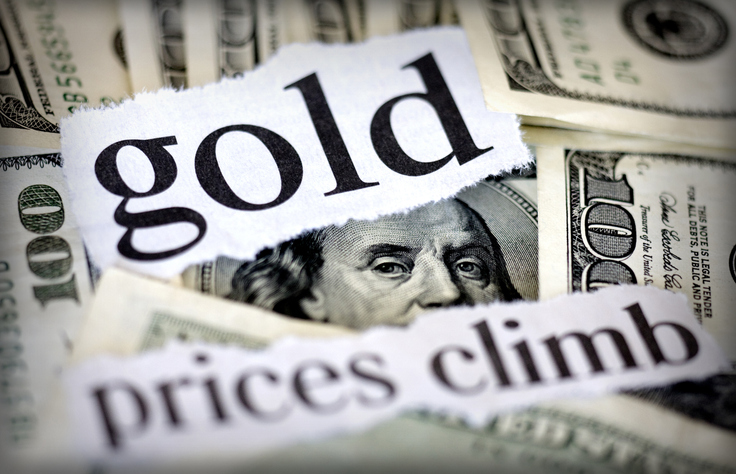 Hundred dollar bills with the words "gold prices climb."