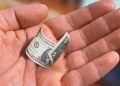 Hand Holding a Shrunken Dollar Bill
