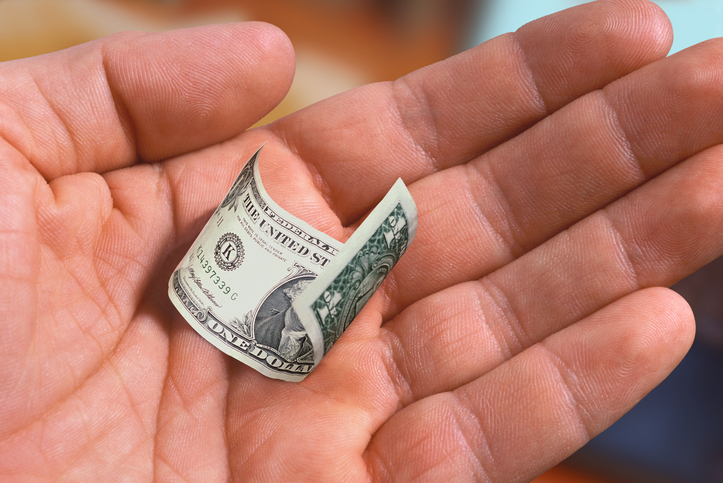 Hand Holding a Shrunken Dollar Bill