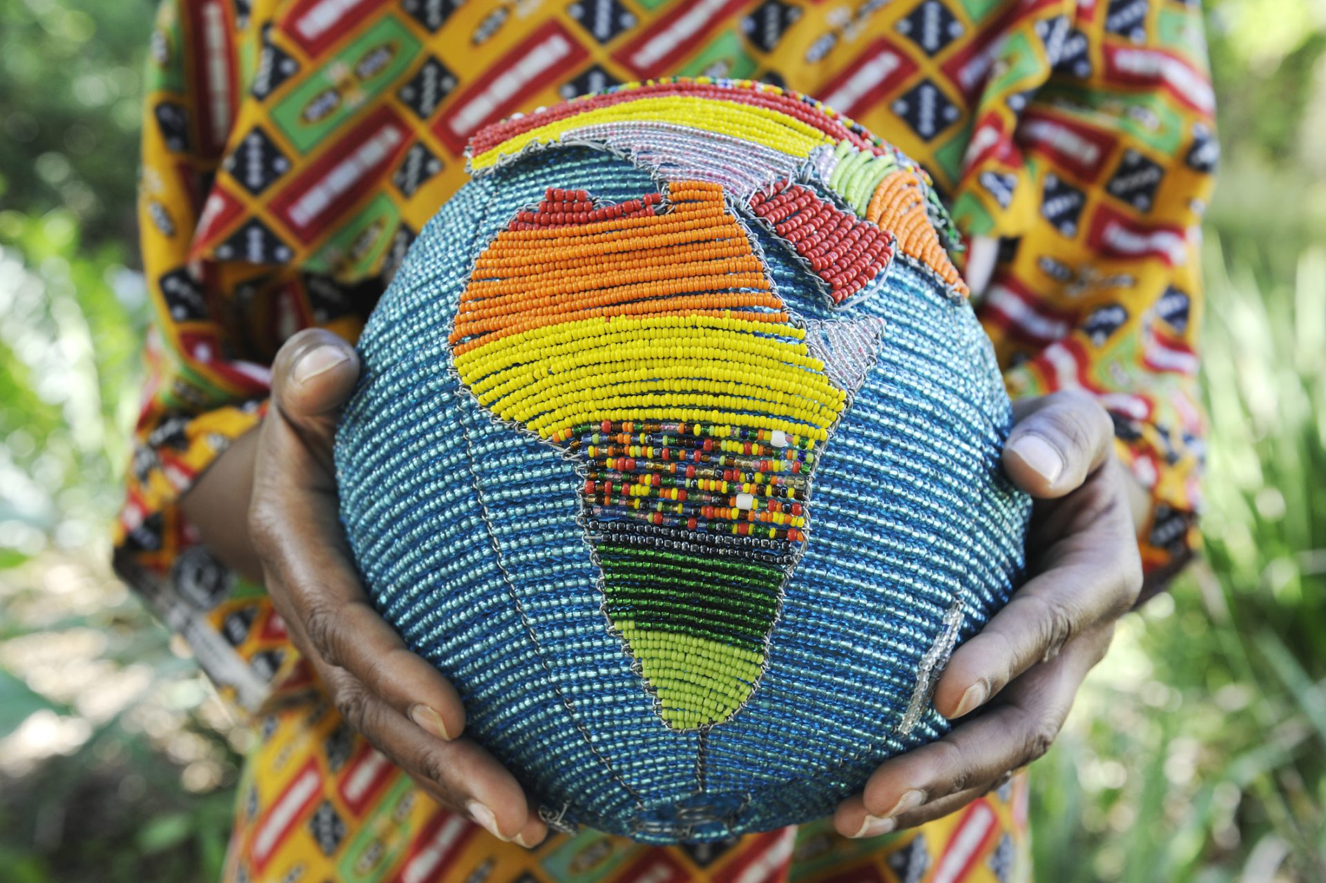 Woman holding a beaded globe with africa showing