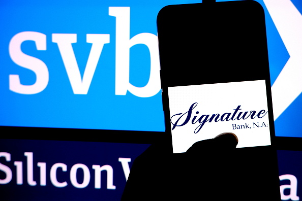 INDIA - 2023/03/19: In this photo illustration, a Signature bank logo is displayed on a smartphone with a Silicon valley Bank(SVB) logo in the background. (Photo Illustration by Avishek Das/SOPA Images/LightRocket via Getty Images)