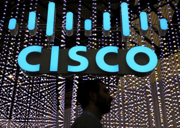 FILE PHOTO: A man passes under a Cisco logo at the Mobile World Congress in Barcelona, Spain February 25, 2019. REUTERS/Sergio Perez/File Photo    GLOBAL BUSINESS WEEK AHEAD