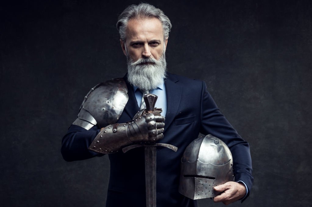 Portrait of a handsome self-confident well dressed businessman holding knight sword
